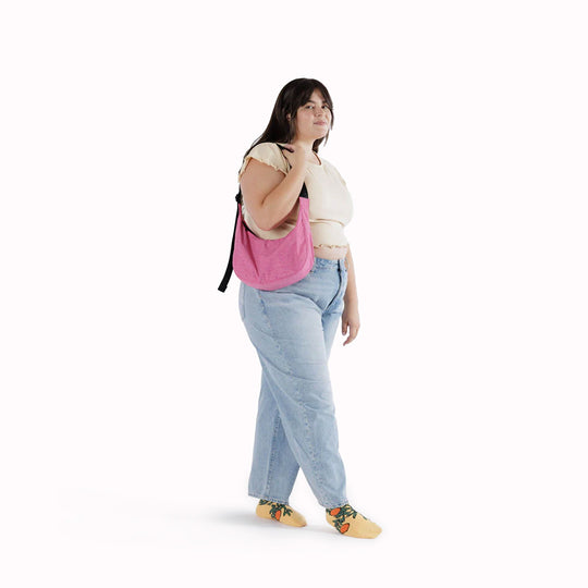 The Medium Crescent Bag in Azalea Pink from Baggu is a stylish and versatile accessory that can complement any outfit. It is made of durable nylon and features a zippered main compartment, an interior slip pocket, and an adjustable shoulder strap.