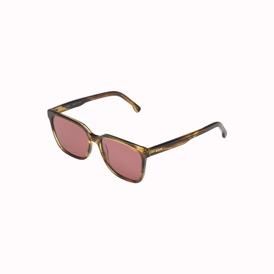 Side view. Strong lines, elegant and fine. The Cole sunglesses from Komono make sure to bring out your best features with their fine acetate frame. Desert Dust is a golden-brown frame colour, which looks really striking with the solid burgundy lenses.