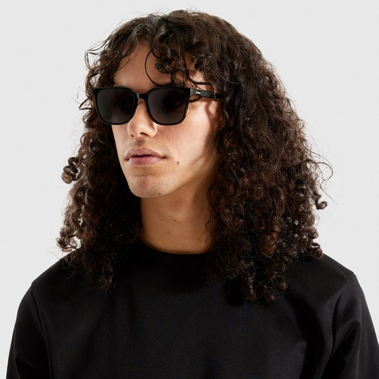 Strong lines, elegant and fine. The Cole makes sure to bring out your best features with its fine acetate frame. As worn by model. The Cole Black Tortoise sunglasses feature a black frame edged with tortoiseshell in Eco Acetate and solid smoke lenses. Subtly striking.