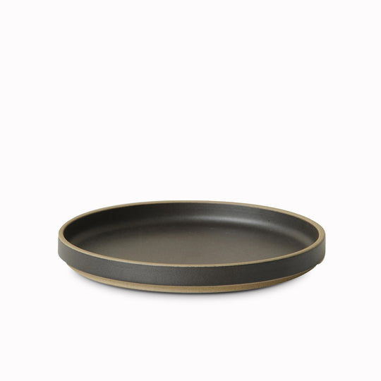 Matt black porcelain plate by Hasami Porcelain is a stackable serving plate with high rimmed edge, suitable for use as a dinner plate or a serving plate for sharing dishes or sides to accompany a meal