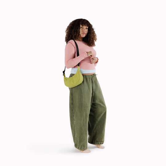 As worn by model - The Small Crescent Bag in Lemongrass from Baggu is a stylish and versatile accessory that can complement any outfit.