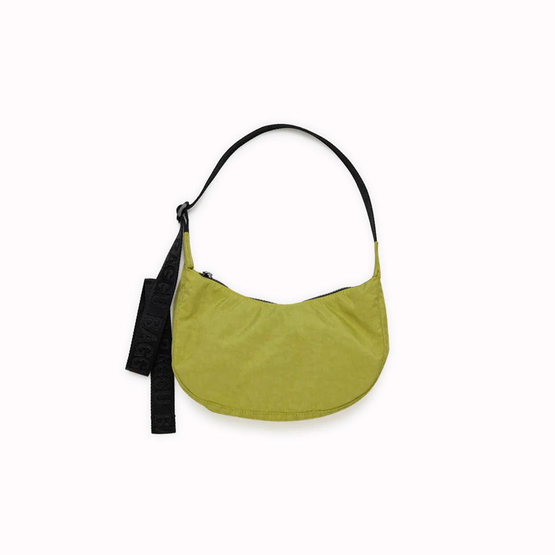 The Small Crescent Bag in Lemongrass from Baggu is a stylish and versatile accessory that can complement any outfit.