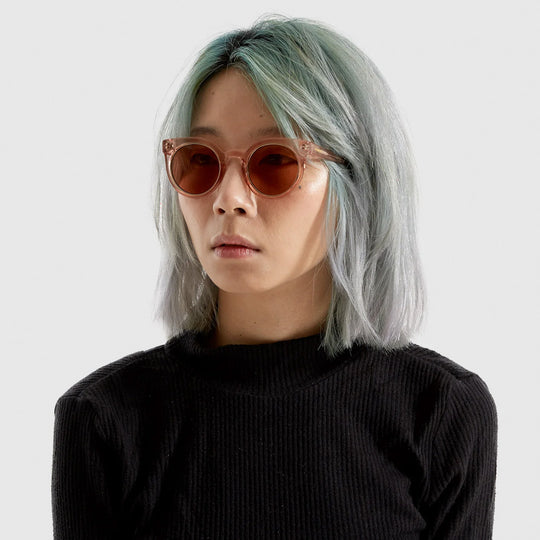 The Lulu as worn by model, featuring a unique combination of round lenses set in a cat-eye frame and offers unparalleled style and protection with a 133mm x 49.4mm Bio Nylon frame, 100% UV400 lenses, and scratch-resistant PC lens. The gorgeous sunglasses feature a translucent rose coloured frame with solid light burgundy lenses. The perfect rose-tinted glasses!