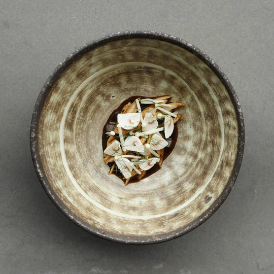 Stunning bowl from Made in Japan with featuring earthy brown glaze with a circular sweep of golden ochre.