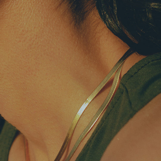 Mio Chain in Gold. Its sinuous, snake-like chain design drapes gracefully around the neck, creating a captivating visual statement. The adjustable length ensures a comfortable fit, allowing you to personalize your style. As Worn.