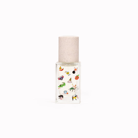 Maison Matine's 'Poom Poom' is a scent that is a carefree ode to life itself... floral, woody, musky and happy! The perfume comes in a beautiful illustrative bottle. 50ml bottle with cap off. Illustrated with cartoon-style imagery.