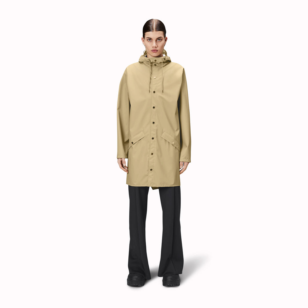 contemporary unisex rain jacket from Danish Outerwear and Lifestyle company Rains. This long Sand coloured rain jacket is characterized by a minimal silhouette in a long design.
