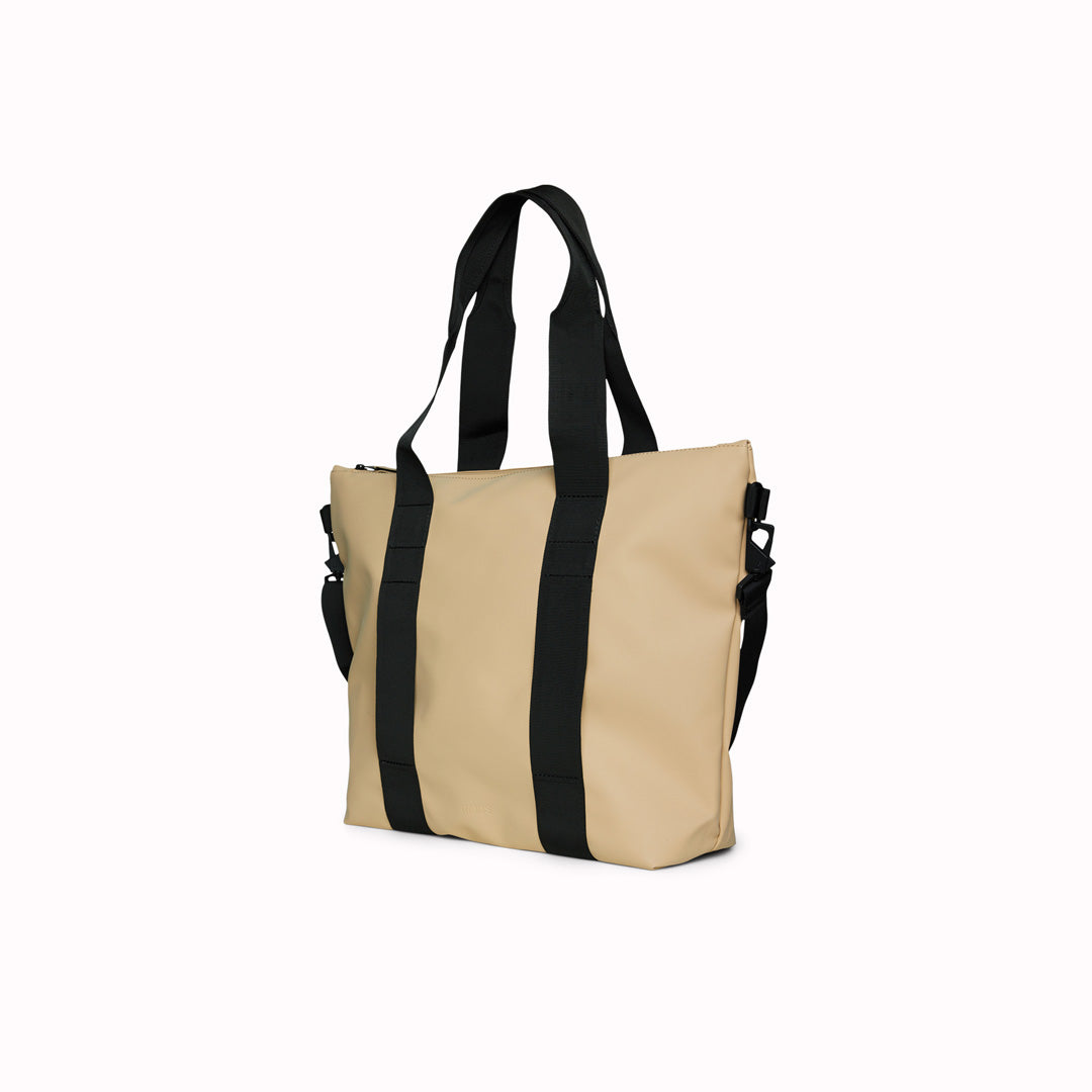 Rains' Tote Bag Mini W3 is a waterproof tote bag and an ideal companion for shopping trips as well as commuting to the office. Functional design elements include a full length coated zip for added water protection, which opens up to reveal a spacious main compartment. Made from Rains’ signature waterproof fabric, engineered for strength, durability and a smooth feel.