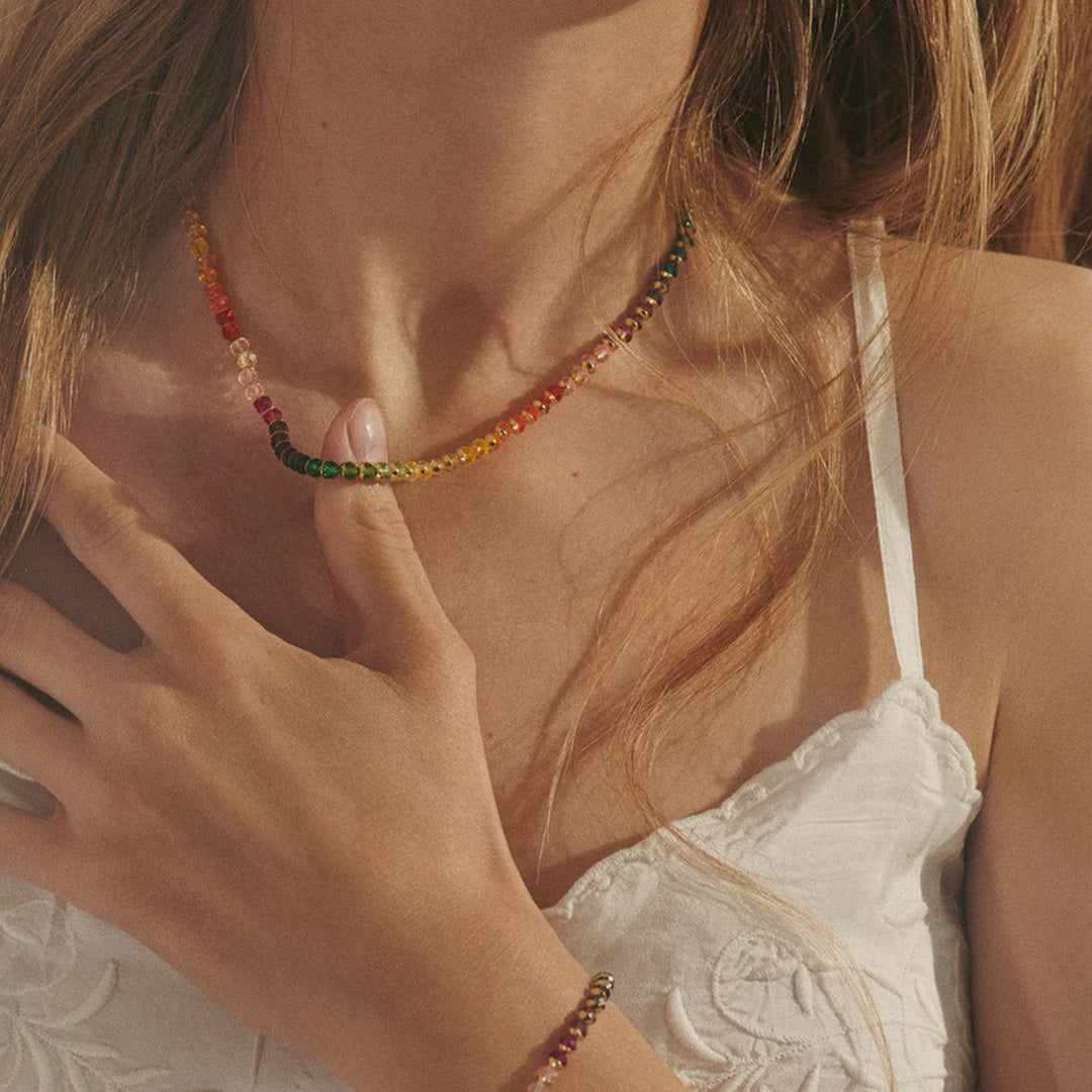 The Anni Lu 'Tennis Kinda' necklace is a playful and elegant piece of jewellery that captures the essence of fun with its multicoloured glass beads and 18-karat gold plating.