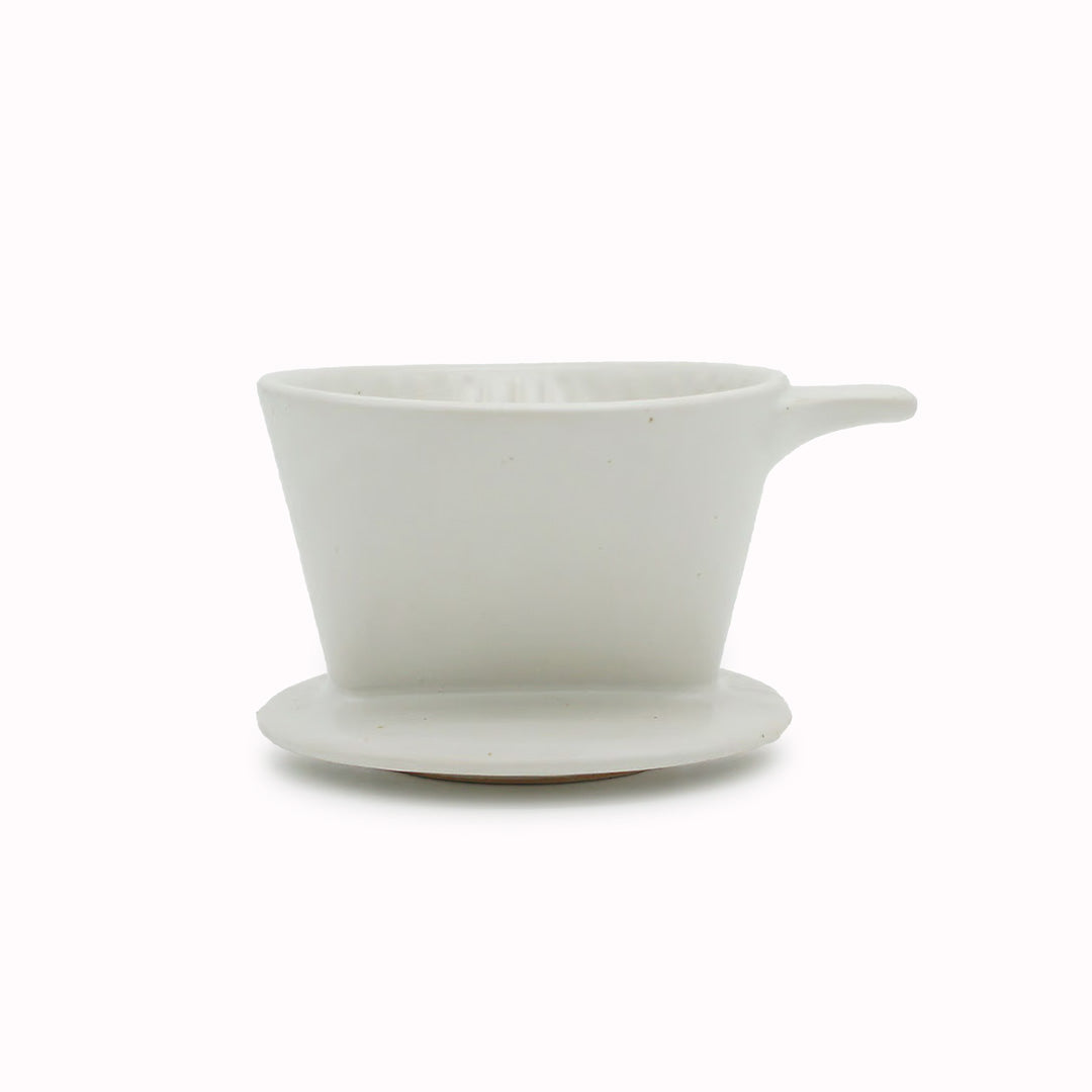 A small dripper for 1 to 2 cups, convenient when you just want to have a quick drink. Looks fantastic when paired with the Ancient Pottery mug. Made of durable stoneware, A gentle white with just the right amount of shine. Granules of iron powder, like vanilla beans, appear on the surface, and the combination with the thick white glaze creates a gentle and nice balance.