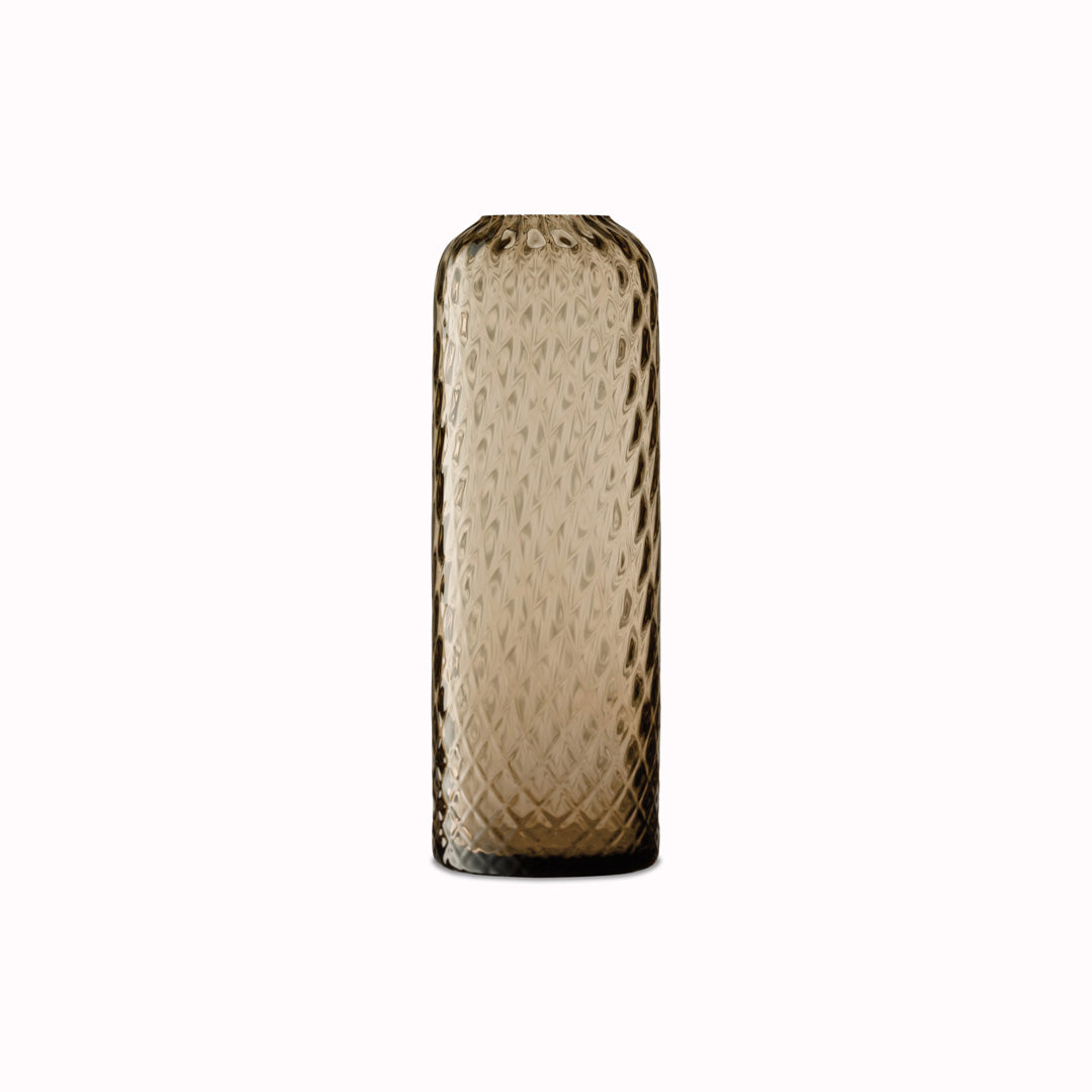 Earth Brown - Dapple Vase is a contemporary, tall and slim shaped vase made from coloured brown mouth blown glass. The Dapple Vase features a beautiful undulating textured surface that is inspired by dappled sunlight on water.