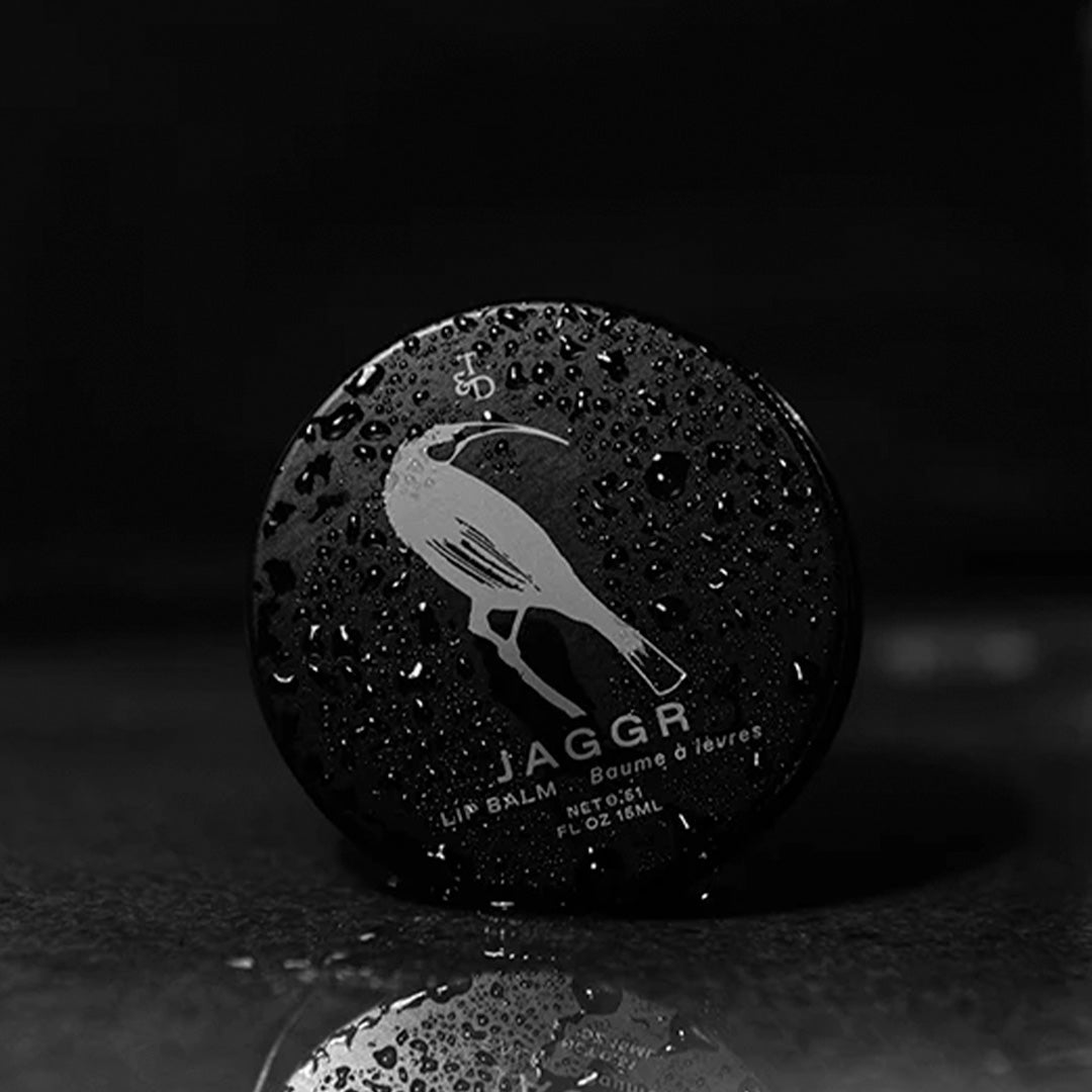 Jaggr, Triumph and Disaster's natural SPF 15 lip balm is SPF 15 protecting your lips from drying out in the sun but is also hydrating with manuka and kawakawa oils to moisten and protect lips from chapping and drying out. - lifestyle image, lip balm tin with drops of water.