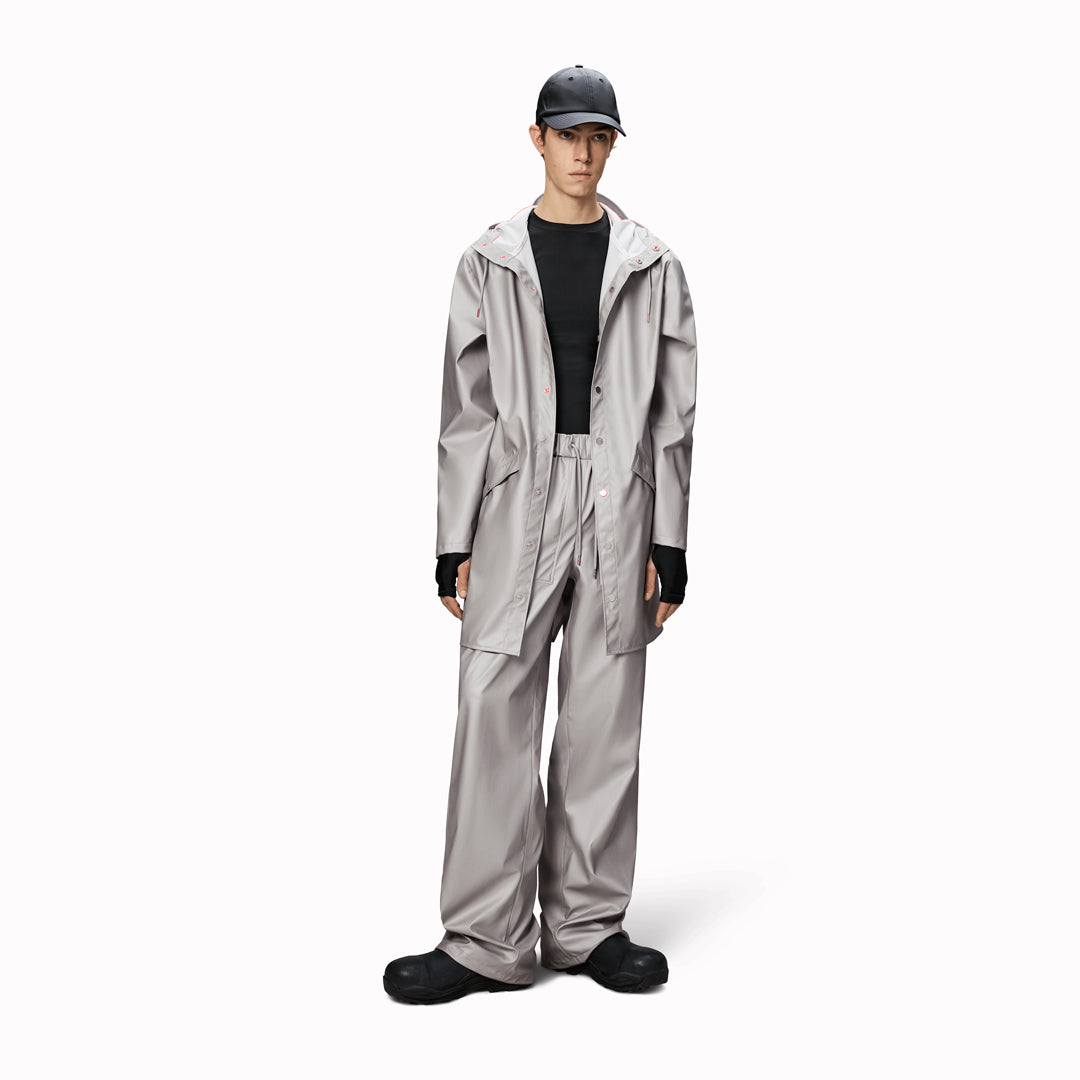 This rain jacket is a long version of Rains' classic rain jacket, featuring a placket with snap fastenings for closure, hood with built-in cap and two side pockets with snaps.