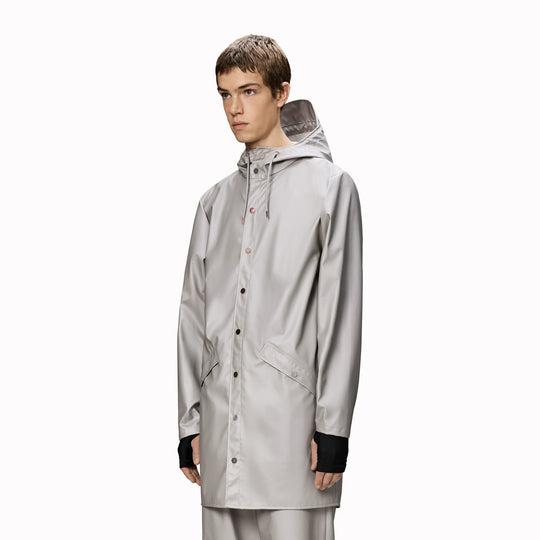 This rain jacket is a long version of Rains' classic rain jacket, featuring a placket with snap fastenings for closure, hood with built-in cap and two side pockets with snaps.