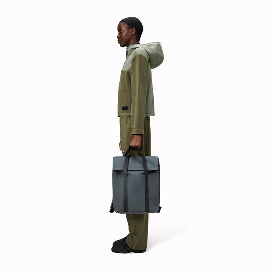 The Rains 2 Way Tote Backpack is characterised by a fold-top opening with the addition signature TPU strap details with top handles.The Rains 2 Way Tote Backpack is characterised by a fold-top opening with the addition signature TPU strap details with top handles.