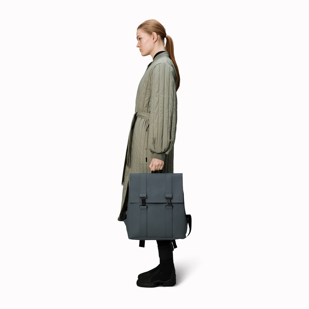 Rains' MSN Bag W3 is their interpretation of the classic school backpack, reimagined for commuters. A minimal silhouette with dual strap and carabiner closure. Made from Rains’ signature waterproof fabric