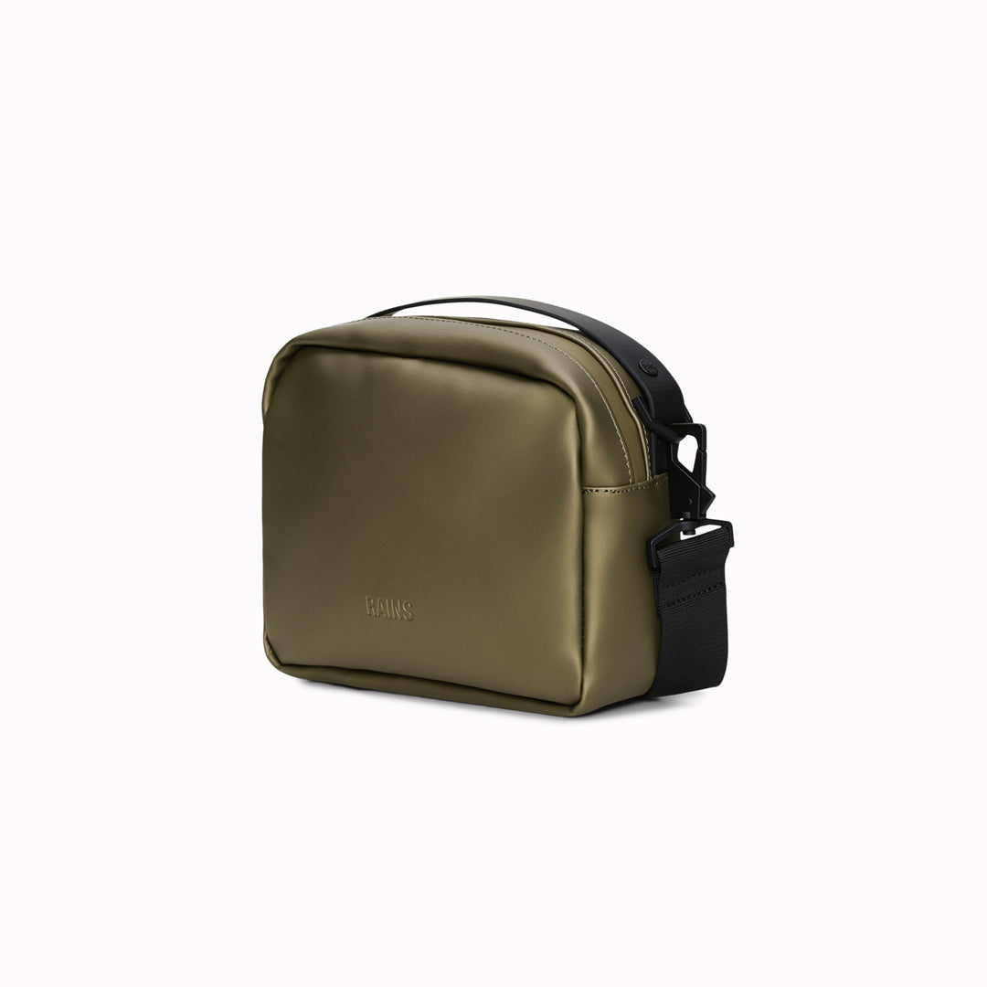 The Rains Box Bag in green is a sleek and minimalist bag crafted from Rains' signature waterproof PU fabric. It features a boxy silhouette with clean lines and a single main compartment secured by a coated zip closure.