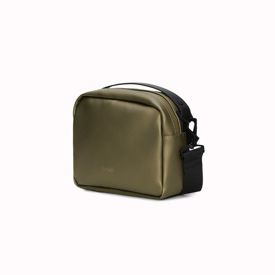 The Rains Box Bag in green is a sleek and minimalist bag crafted from Rains' signature waterproof PU fabric. It features a boxy silhouette with clean lines and a single main compartment secured by a coated zip closure.