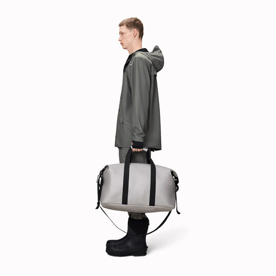 The Hilo Weekend Bag by Rains is a great contemporary gym or overnight bag. It features a single main compartment, carry handles, a detachable shoulder strap, and adjustable lock slider buckles on the sides.