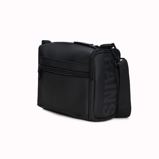 The Rains Texel Crossbody bag in black is a sleek and functional accessory designed for travel and everyday use. Crafted from Rains' signature waterproof matte-shell material, this bag offers durable protection against the elements.