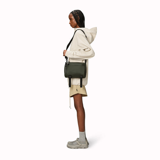 The Rains Texel Crossbody bag in green is a sleek and functional accessory designed for travel and everyday use. Crafted from Rains' signature waterproof matte-shell material, this bag offers durable protection against the elements.