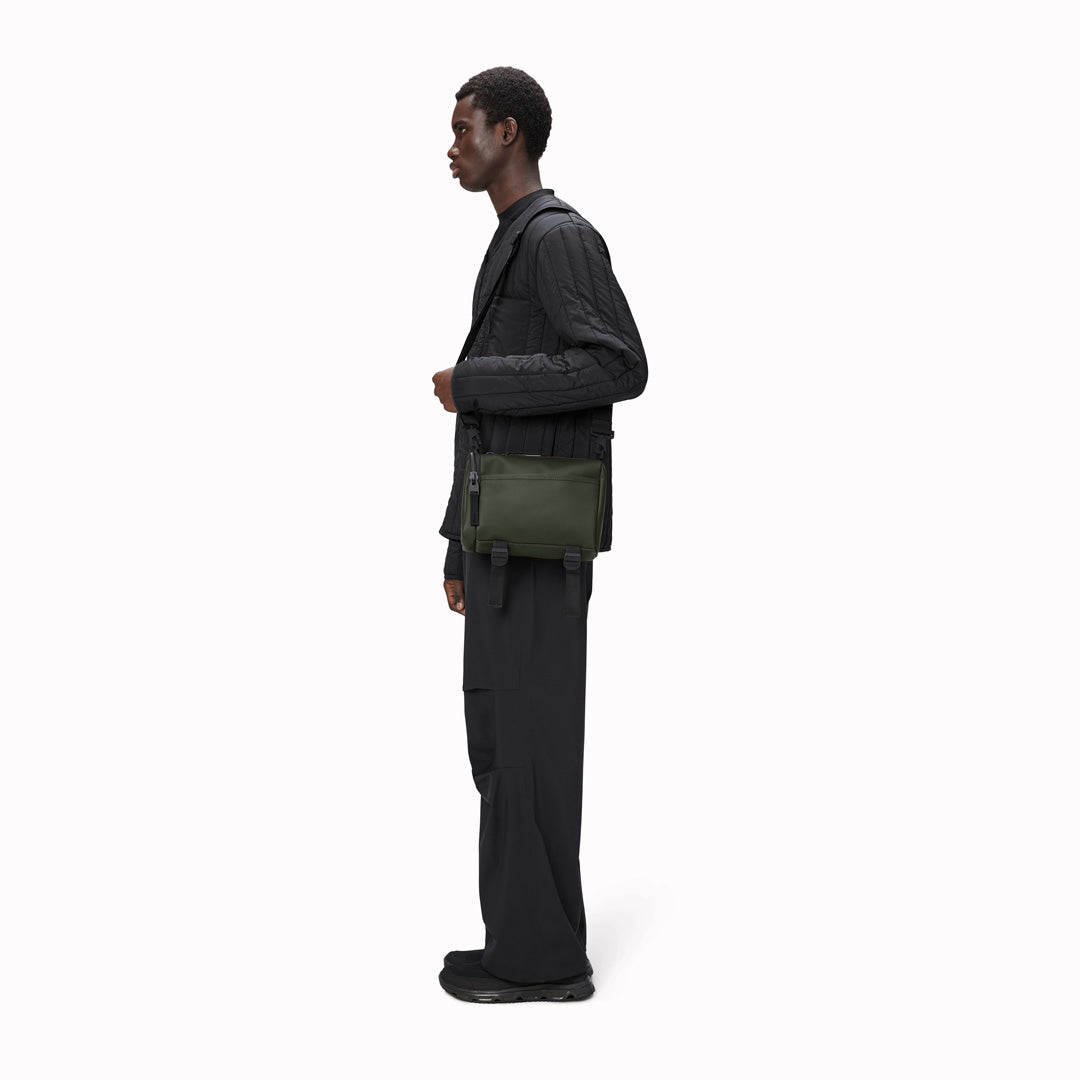 The Rains Texel Crossbody bag in green is a sleek and functional accessory designed for travel and everyday use. Crafted from Rains' signature waterproof matte-shell material, this bag offers durable protection against the elements.