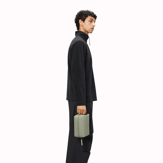 SS25 collection Wash Bag by Rains in Earth. A unisex wash bag by Rains featuring one main compartment with inside sleeve pockets and is large enough to fit one’s essential toiletries.