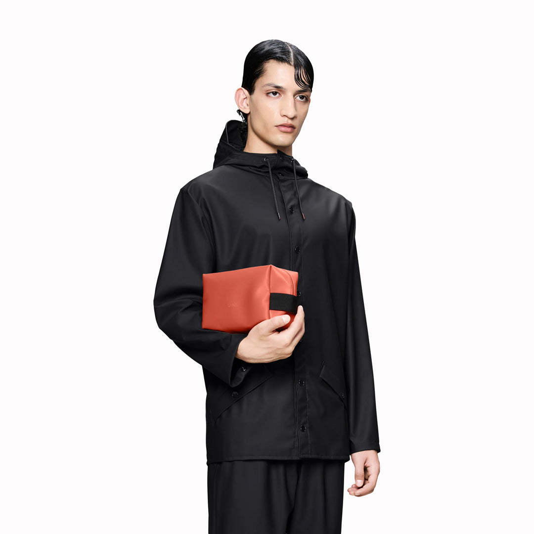 SS26 Wash Bags by Rains in their new season Kiln colour. A cube shaped wash bag with one main compartment with inside sleeve pockets and is large enough to fit one’s essential toiletries.