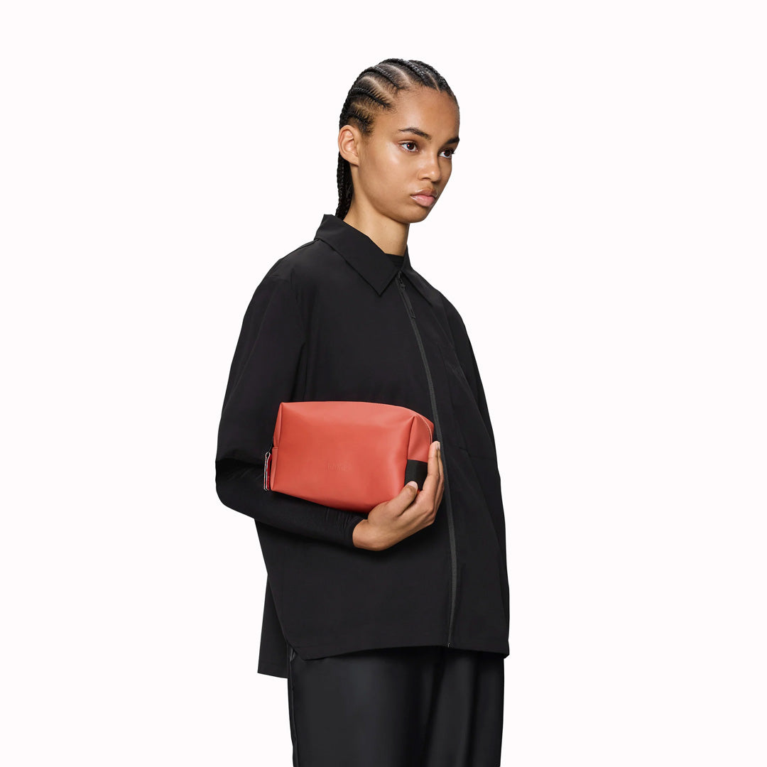 SS26 Wash Bags by Rains in their new season Kiln colour. A cube shaped wash bag with one main compartment with inside sleeve pockets and is large enough to fit one’s essential toiletries.