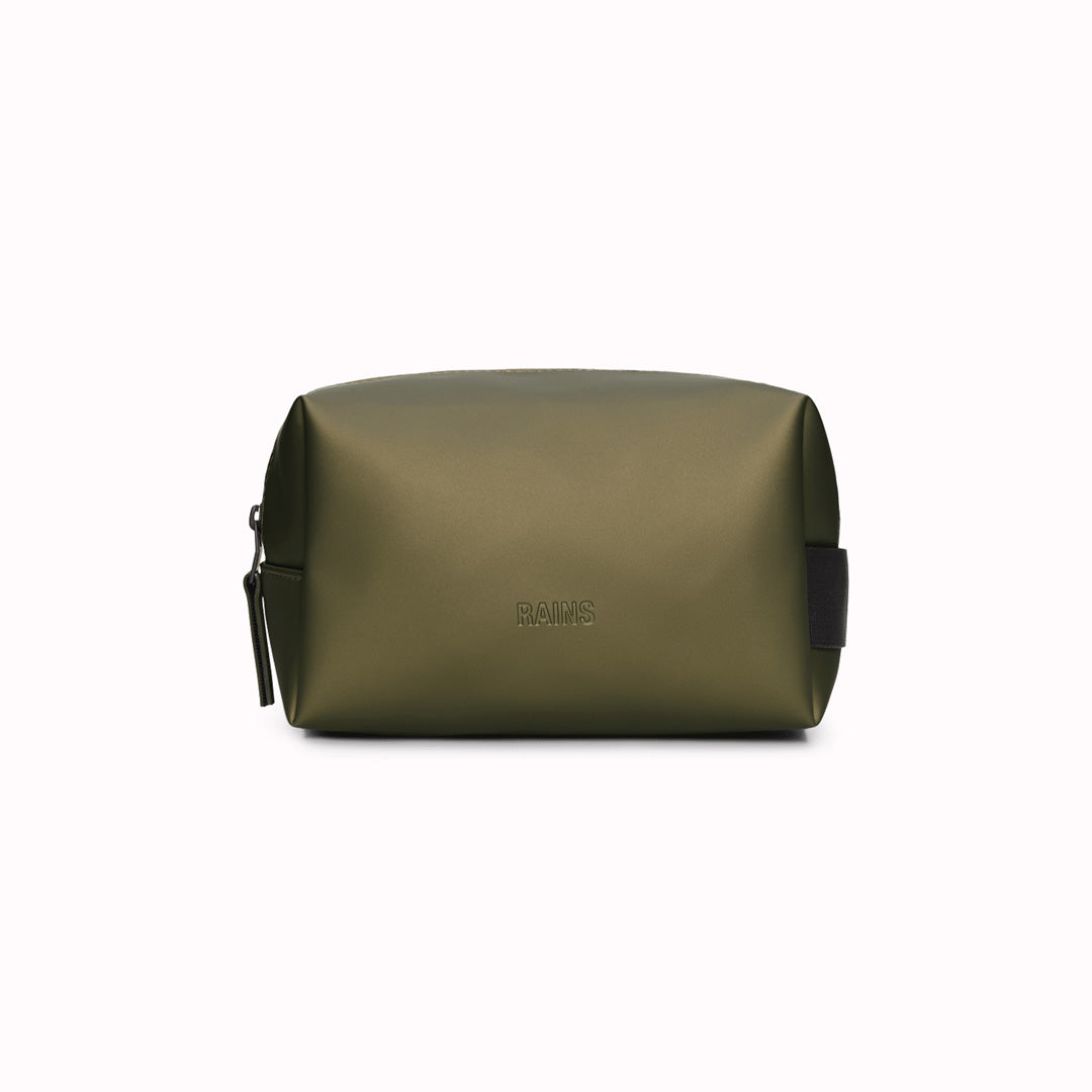 SS25 collection Wash Bag by Rains in Revel, a muted moss green. This unisex wash bag by Rains featuring one main compartment with inside sleeve pockets and is large enough to fit one’s essential toiletries. Made from a smooth, waterproof fabric&nbsp;it also&nbsp;has a webbing grab handle and a water-repellent zipper.