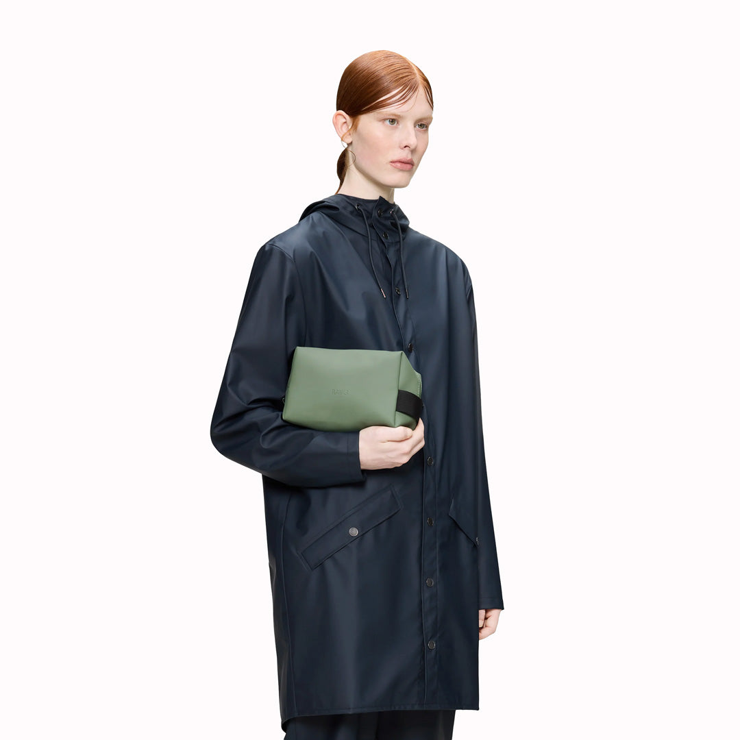 SS26 Wash Bags by Rains in their new season Well colour. A cube shaped wash bag with one main compartment with inside sleeve pockets and is large enough to fit one’s essential toiletries.