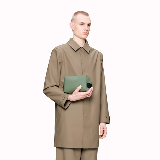 SS26 Wash Bags by Rains in their new season Well colour. A cube shaped wash bag with one main compartment with inside sleeve pockets and is large enough to fit one’s essential toiletries.