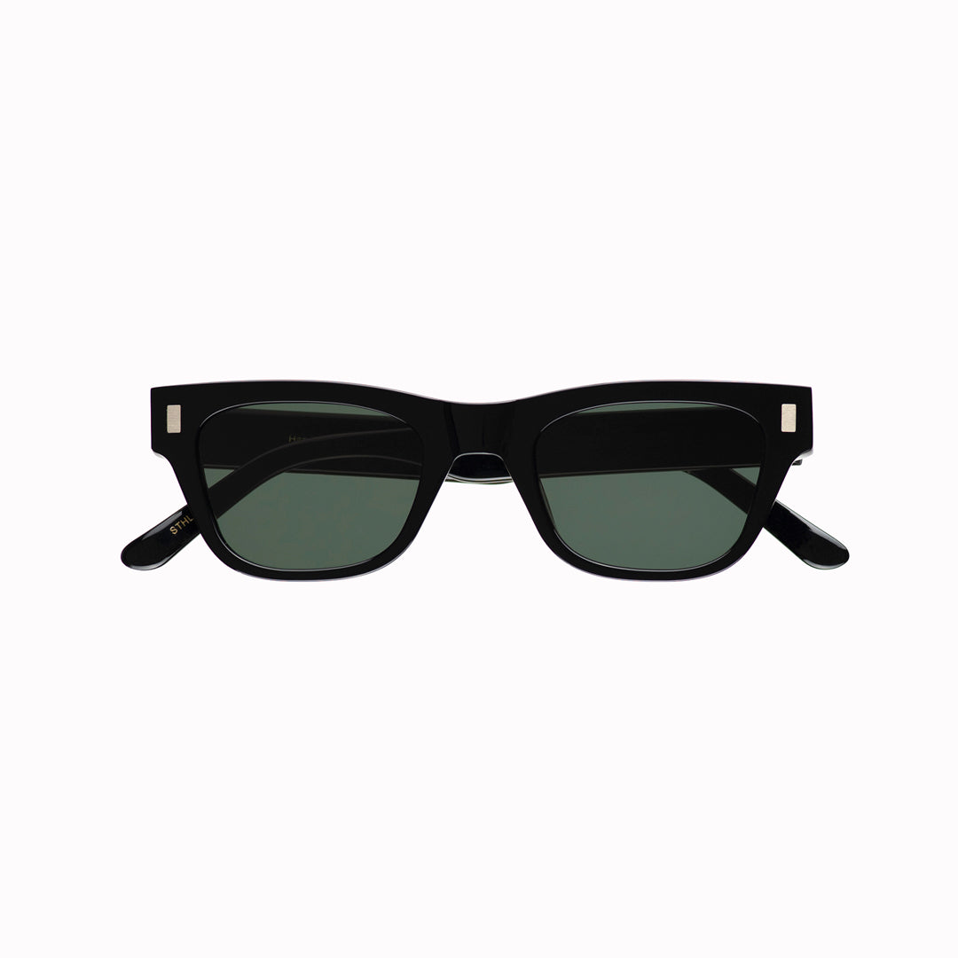 Monokel Aki Sunglasses in Black with a solid green lens sits low on the bridge with a slim, rectangular profile that keeps things sharp
