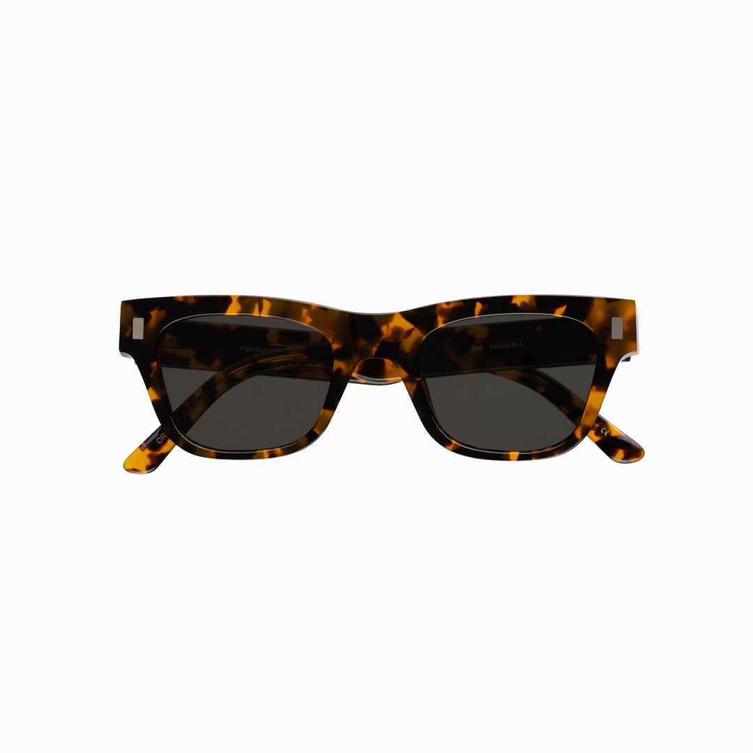 Monokel Aki Sunglasses with a Havana frame with a solid grey lens sits low on the bridge with a slim, rectangular profile that keeps things sharp