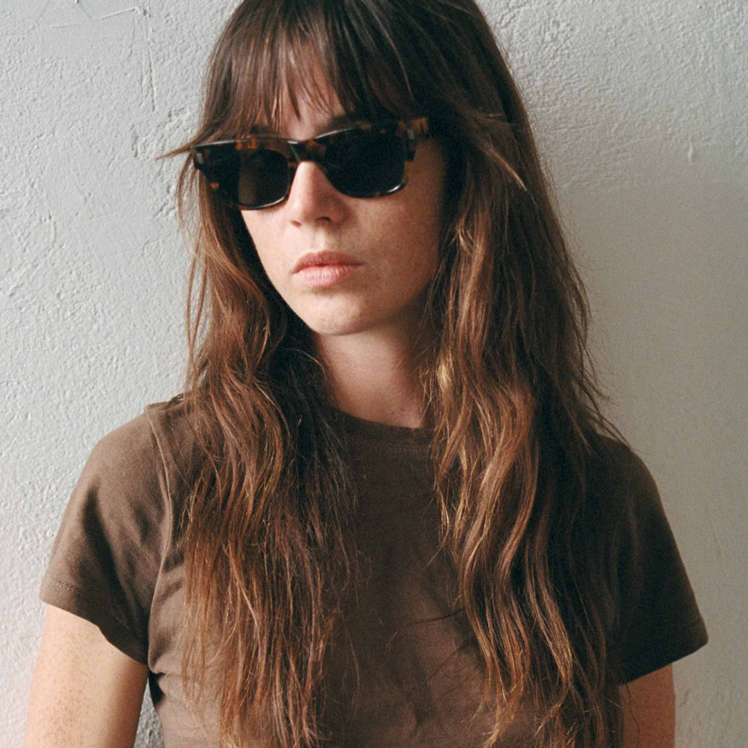 Monokel Aki Sunglasses with a Havana frame with a solid grey lens sits low on the bridge with a slim, rectangular profile that keeps things sharp