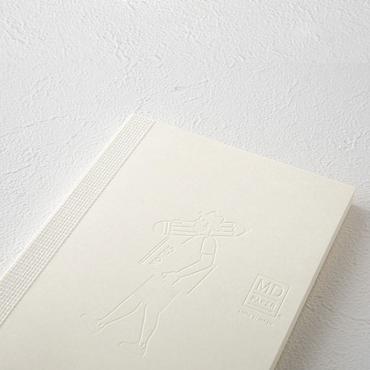 Emboss Detail - This A6 plain paper notebook has an off white cover embossed with some ace artwork by Andrew Joyce featuring a man with a giant pencil and notebook. The MD paper logo is also embossed.  
