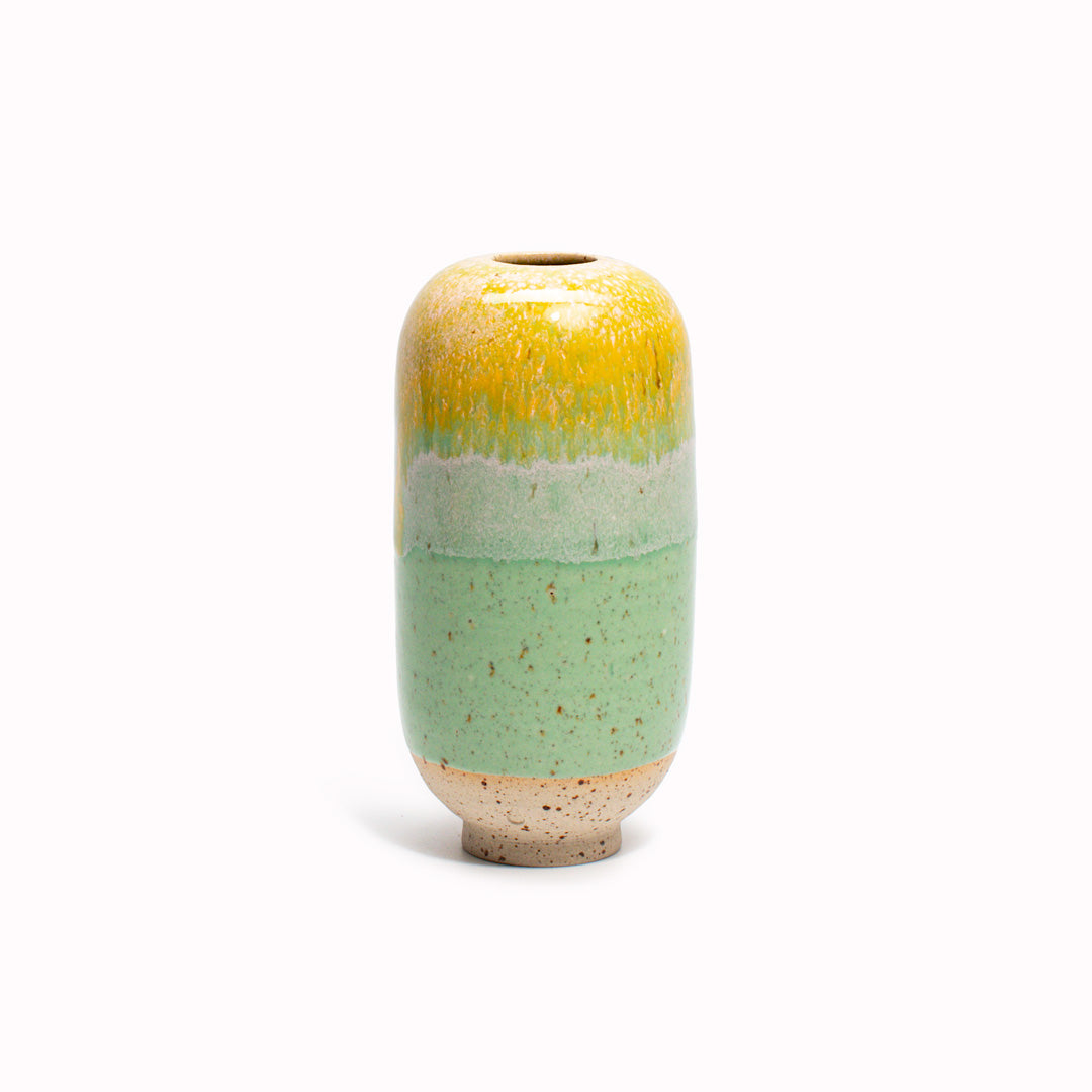 The Apple Bud design is hand-thrown in watertight stoneware. Due to the rounded taper at the top of the vase, the glaze melts down the sides of the cylindrical vase mimicking melting ice.