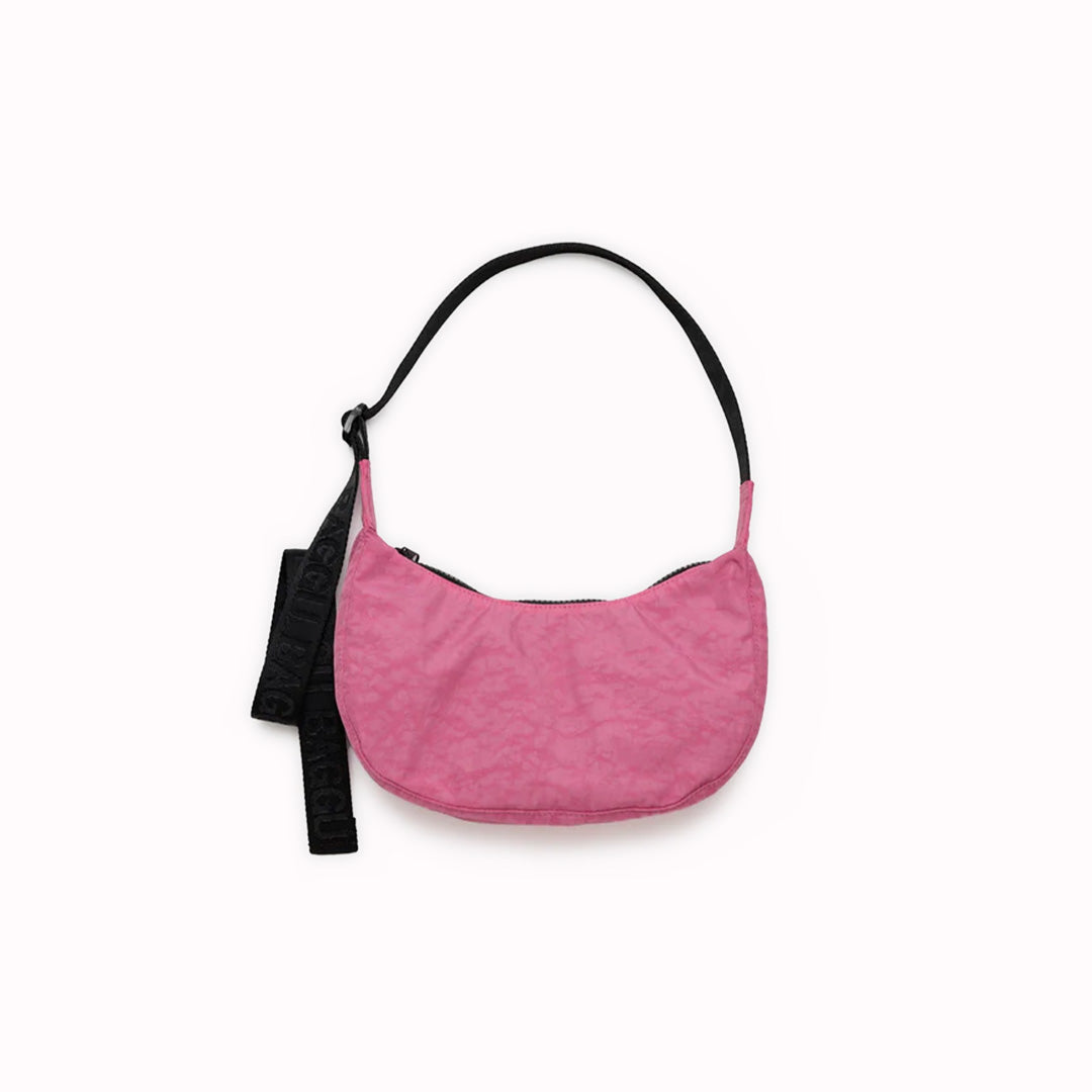 The Small Crescent Bag in Azalea Pink from Baggu is a stylish and versatile accessory that can complement any outfit.