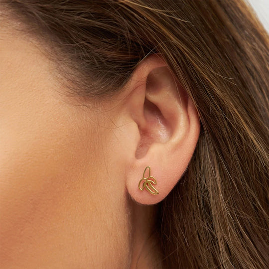 LULU Copenhagen's gold plated Banana earring is a cute nod to Pop Art for a playful look. As Worn Detail.