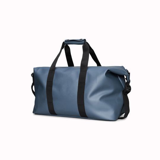 The Hilo Weekend Bag by Rains is a great contemporary gym or overnight bag. It features a single main compartment, carry handles, a detachable shoulder strap, and adjustable lock slider buckles on the sides.