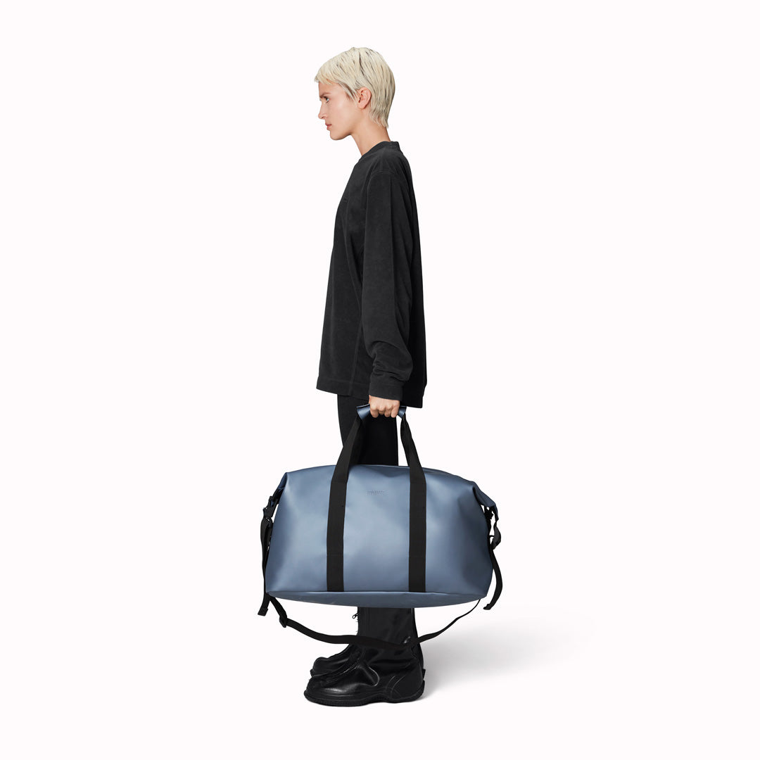 The Hilo Weekend Bag by Rains is a great contemporary gym or overnight bag. It features a single main compartment, carry handles, a detachable shoulder strap, and adjustable lock slider buckles on the sides.