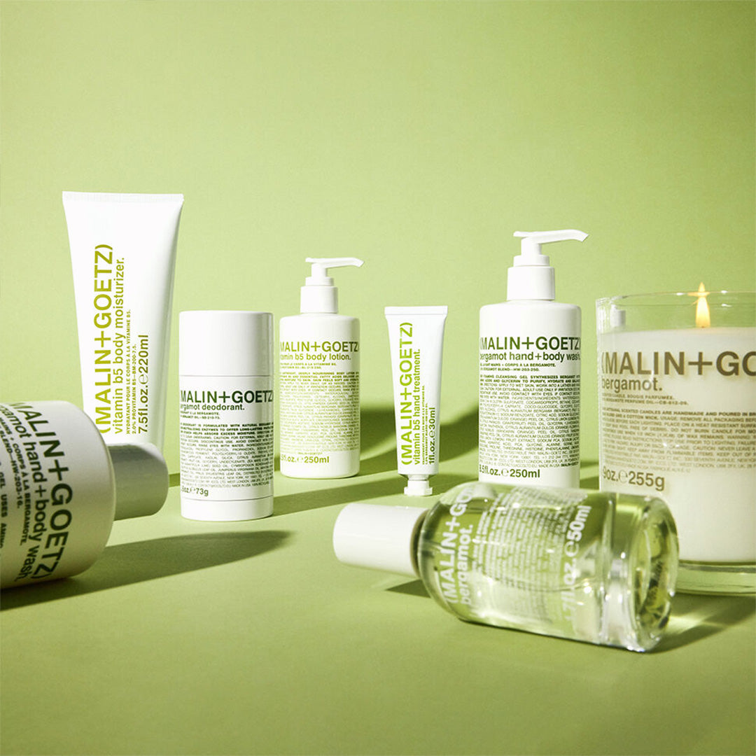 Collection of Malin+Goetz Bergamot skincare products on a green background