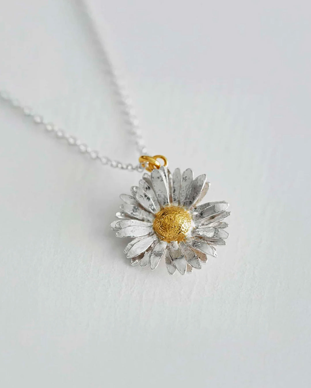 Inspired by nature, a replica daisy in a mix of recycled sterling silver and fairmined gold plate.