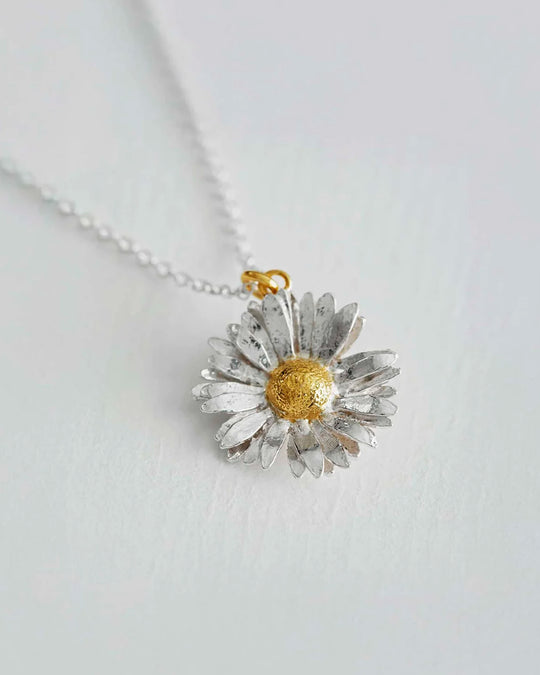 Inspired by nature, a replica daisy in a mix of recycled sterling silver and fairmined gold plate.