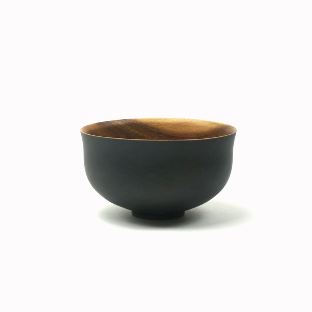 Japanese style Acacia wood serving bowl from Dutch company Kinta, who produce contemporary ceramics and homeware. Round in shape with tapered edge, the serving bowl is black on its exterior and natural acacia wood colour on the interior. It has a diameter of 16cm and is a great size for serving salads or other dishes shared at the table.