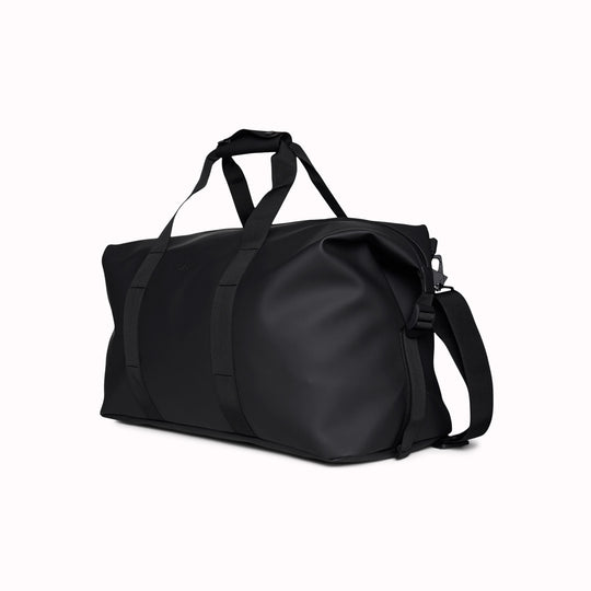 The Hilo Weekend Bag by Rains is a great contemporary gym or overnight bag. It features a single main compartment, carry handles, a detachable shoulder strap, and adjustable lock slider buckles on the sides. This brilliant waterproof duffel bag is cut from Rains’ signature waterproof PU coated fabric and is finished with coated zip and matte hardware.