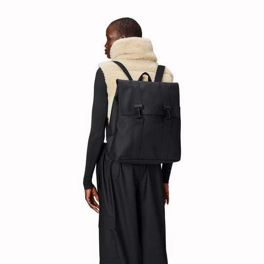 As Worn by model - Rains' MSN Bag W3 is their interpretation of the classic school backpack, reimagined for commuters. A minimal silhouette with dual strap and carabiner closure. Made from Rains’ signature waterproof fabric, with an internal laptop pocket and a roomy main compartment.