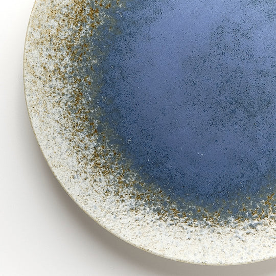 Blue Pool Serving Plate has a slightly matt edge and a glazed blue middle resembling a serene pool. It is ideal for serving salads, appetizers, desserts and more.