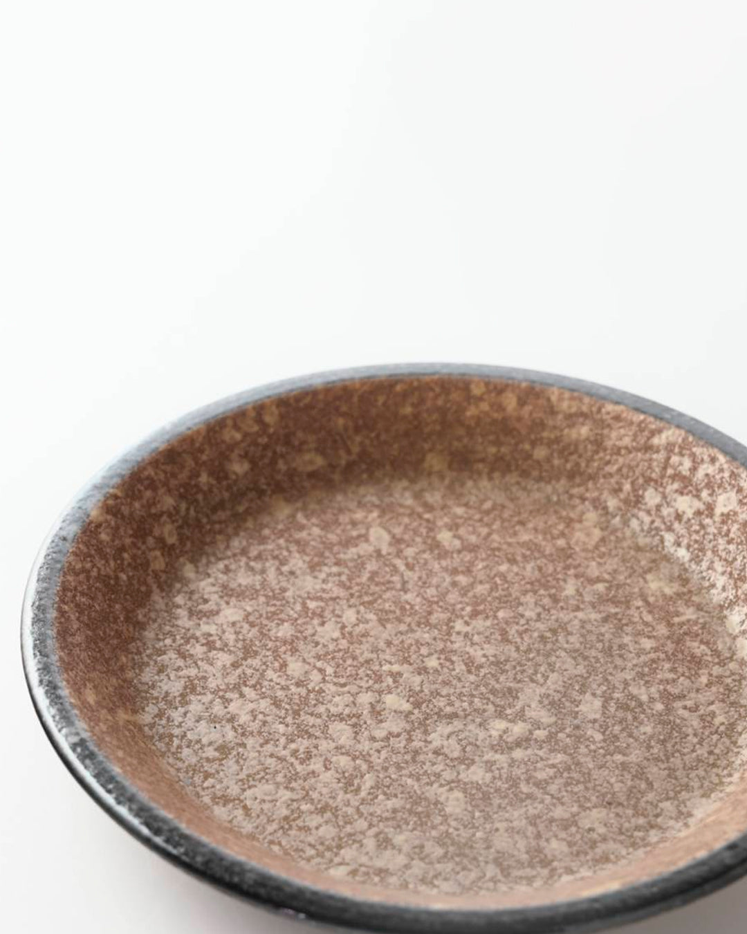 Rough textured plate with matt glaze in a coppery brown shade that catches the light to reveal a golden shimmer. Use to serve side dishes and snacks.