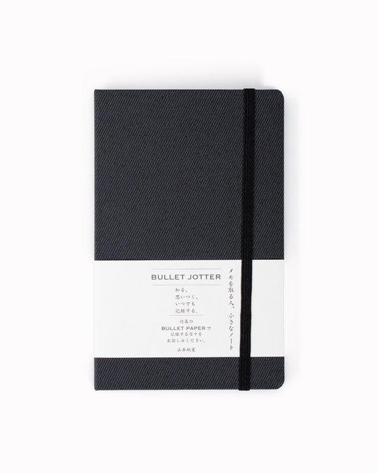 The Bullet Jotter by Yamamoto Paper is a modular note-taking system comprising an outer cover jacket with internal space to hold 2 bullet paper pads. 
